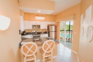 cocina con 2 sillas y encimera en WorldQuest Orlando Resort, en Orlando