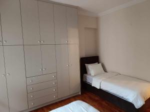 a bedroom with a bed and a large white cabinet at Simply Athens Apartment in Athens