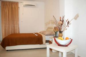 ein Schlafzimmer mit einem Bett und einer Obstschale auf einem Tisch in der Unterkunft Apartmani Bonik in Budva