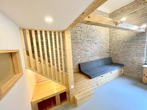 a room with a bench and a brick wall at Lavender Circus Hand Drawn Apartments in Budapest