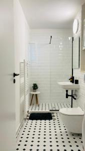 シビウにあるCozy Apartmentの白いバスルーム(洗面台、トイレ付)