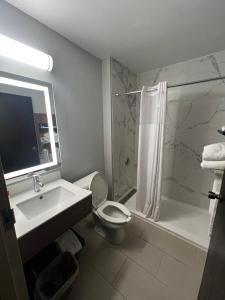 a bathroom with a sink and a toilet and a shower at Microtel Inn by Wyndham Atlanta Airport in Atlanta +9 photos
