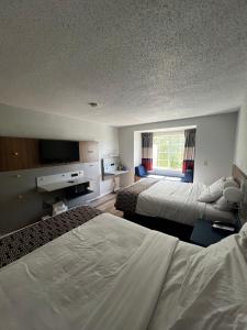 a hotel room with two beds and a flat screen tv at Microtel Inn by Wyndham Atlanta Airport in Atlanta