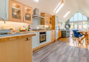 a kitchen with wooden cabinets and a table and a dining room at The Sun Deck in Aldeburgh