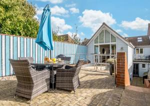 a patio with a table and chairs and an umbrella at The Sun Deck in Aldeburgh