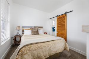 a bedroom with a large bed and a window at The City Roost at Timberline Flats with Balcony in Traverse City