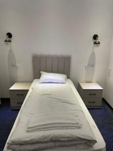 una camera da letto con un grande letto con due comodini di Gastpark Hotel a Manching