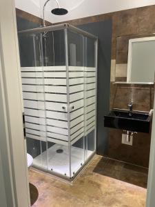 a glass shower in a bathroom with a sink at Gastpark Hotel in Manching