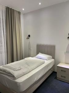 a bedroom with a bed and a window at Gastpark Hotel in Manching