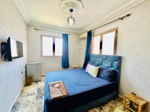 a bedroom with a blue bed with blue curtains at Familiale Chambre calm wifi Hanae in Marrakesh