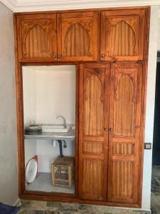 a wooden cabinet with a sink in a room at Familiale Chambre calm wifi Hanae in Marrakech