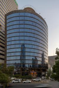 فندق مونتانا العزيزية في مكة المكرمة: مبنى زجاجي كبير فيه سيارات تقف امامه