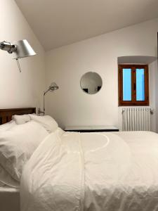 een slaapkamer met een wit bed en een raam bij Appartamento Vecchia Farmacia 111 in Scarperia