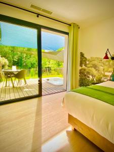 a bedroom with a bed and a sliding glass door at Chambres avec Jacuzzi privatif - Kassiopée Bed & Spa in Albi