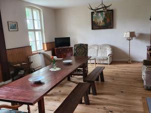 ein Wohnzimmer mit einem Holztisch und Stühlen in der Unterkunft Holiday house, Golssen in Golßen