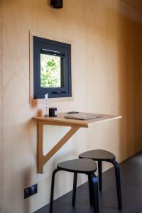 una scrivania con due sgabelli in una stanza con finestra di Modern Tiny House 