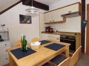 una cocina con una mesa de madera y una botella de vino en Apartment house Atlanta, Pellworm, en Pellworm