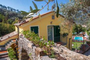 een klein geel huis met een stenen muur bij B&B Vignola in Levanto