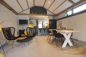 OudewaterにあるBed & Breakfast De Ruige Weideの椅子、テーブル、テレビが備わる客室です。