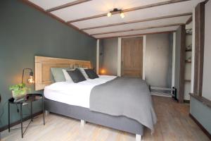 1 dormitorio con 1 cama grande y 1 mesa en Bed & Breakfast De Ruige Weide, en Oudewater