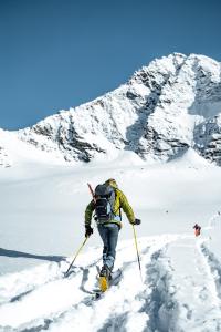 una persona con una mochila esquiando por una montaña nevada en Haus SaRo, en Hopfgarten im Brixental