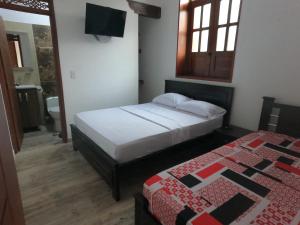 HOTEL COLONIAL في بوغا: غرفة نوم بسريرين في غرفة