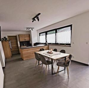 comedor y cocina con mesa y sillas en Bergblick Wohnung Posch, en Imst