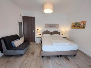 1 dormitorio con 1 cama y 1 silla en Cascina Cortese, en Druento