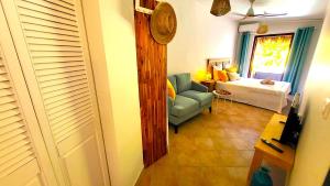 ein Wohnzimmer mit einem blauen Stuhl und einem Bett in der Unterkunft Sweet Payot : Studio avec Spa privé et piscine in Le Lamentin