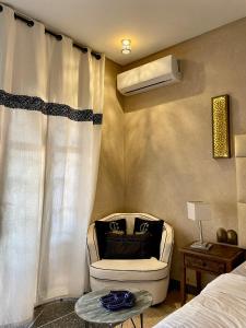 馬拉喀什的住宿－Dar Si Allal，一间卧室配有一张床、一把椅子和风扇