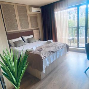 a bedroom with a bed and a large window at Argisht Luxury Apartment Golden Sands in Golden Sands