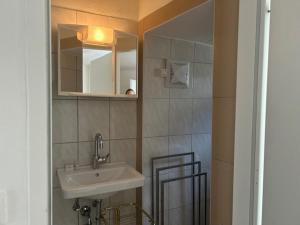uma casa de banho com um lavatório e um espelho em Spitz West em Spitz