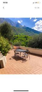 a picnic table and benches on a patio with a view at Etti's House in Malcesine