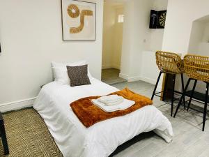 Una cama blanca con dos toallas encima. en No 1 - Central Apartment en Gloucester