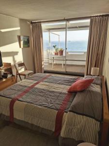 a bedroom with a bed with a view of the ocean at Apto. Reñaca 193 - Viña del Mar in Viña del Mar