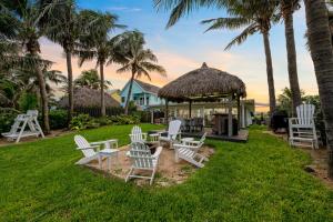 - un groupe de chaises blanches et un kiosque dans l'établissement Vista Del Mar Oceanfront Home Stunning Views Backyard Oasis, à Cocoa Beach