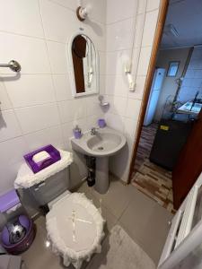 baño con aseo y lavabo con una cruz. en Cabañas LUPA, en Punta Arenas