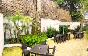 un patio con tavoli, sedie e un ombrellone di Granada Hostel a Bogotá