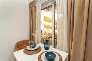a white table with two plates and a vase on it at Praia da Rocha Beach Bright Apartment 50 m walk from the ocean in Portimão