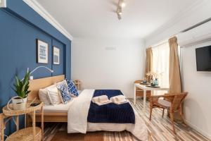 a bedroom with a bed and a blue wall at BnB Homes Praia da Rocha Beach Bright Apartment 50 m away from the ocean in Portimão +28 photos