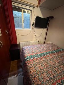 Habitación pequeña con cama y ventana en Cabañas LUPA, en Punta Arenas