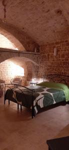 ein Schlafzimmer mit einem Bett in einer Steinmauer in der Unterkunft Dimora Cleó in Putignano