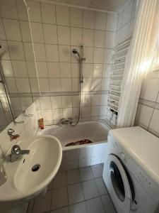 a bathroom with a sink and a tub with a washing machine at Haus Elli 