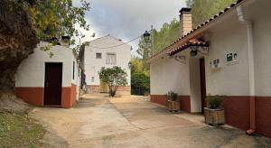 Casa rural Molino Jaraiz في يستي: زقاق مع مبنى أبيض ومنزل