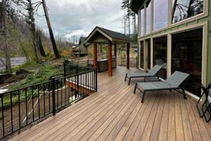 een houten terras met 2 stoelen en een prieel bij McKenzie River Retreat in Vida