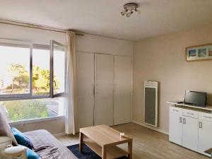 a living room with a couch and a table at Studio - Pleine Mer - 1 avenue des Pays de Monts - 1-1 in Saint-Jean-de-Monts