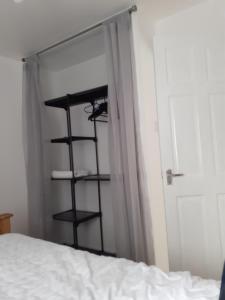a black shelf next to a bed next to a door at Heart of Deptford in London