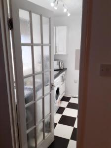 a kitchen with a black and white checkered floor at Heart of Deptford in London