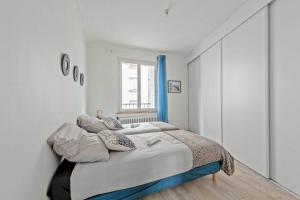 a white bedroom with a bed with pillows on it at Ty'brestoise proche centre - jardin- parking gratuit in Brest