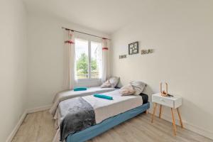 a bedroom with two beds and a window at Ty'brestoise proche centre - jardin- parking gratuit in Brest